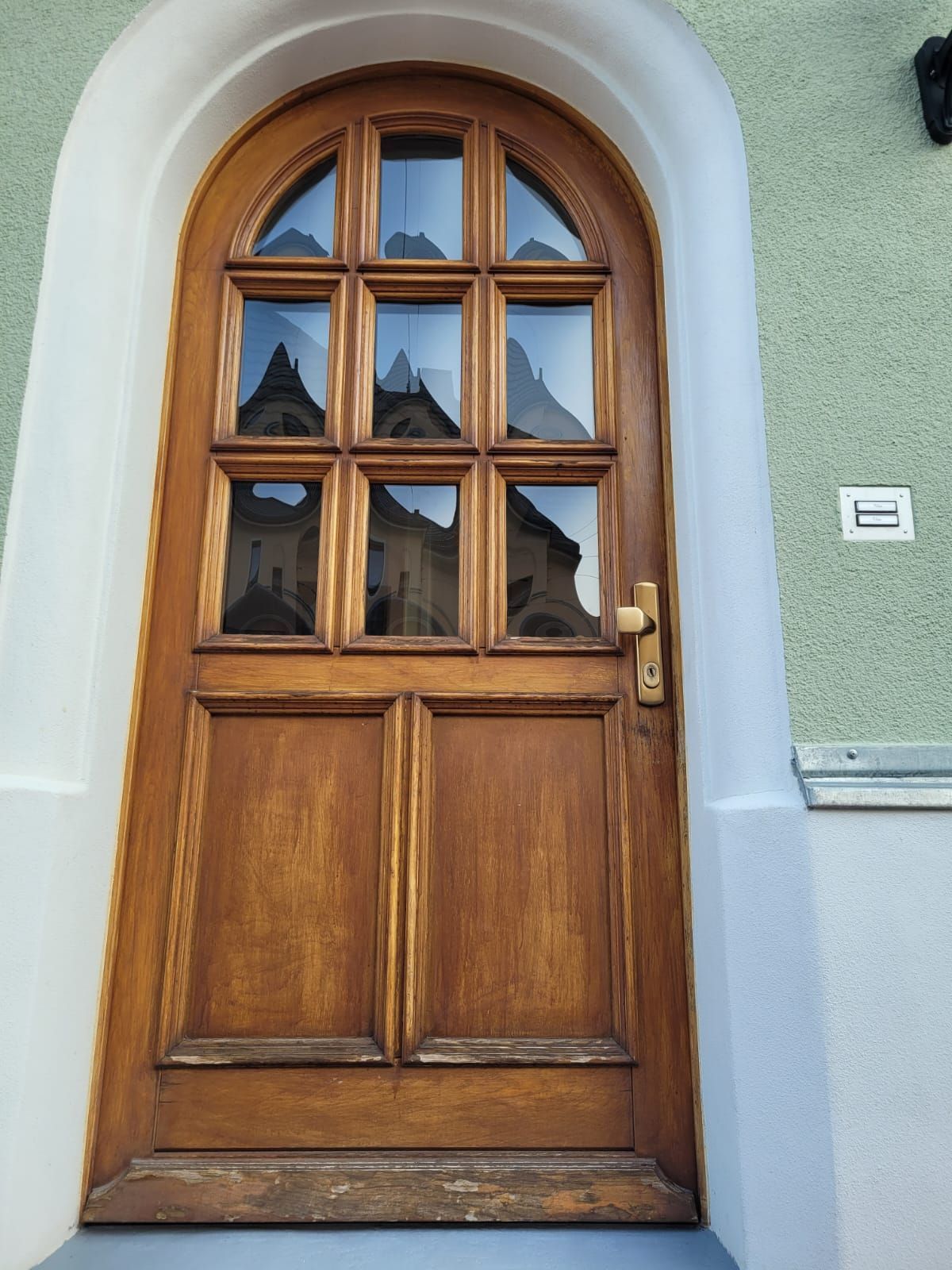 Eine Holztür mit Bogenfenstern an einem Gebäude