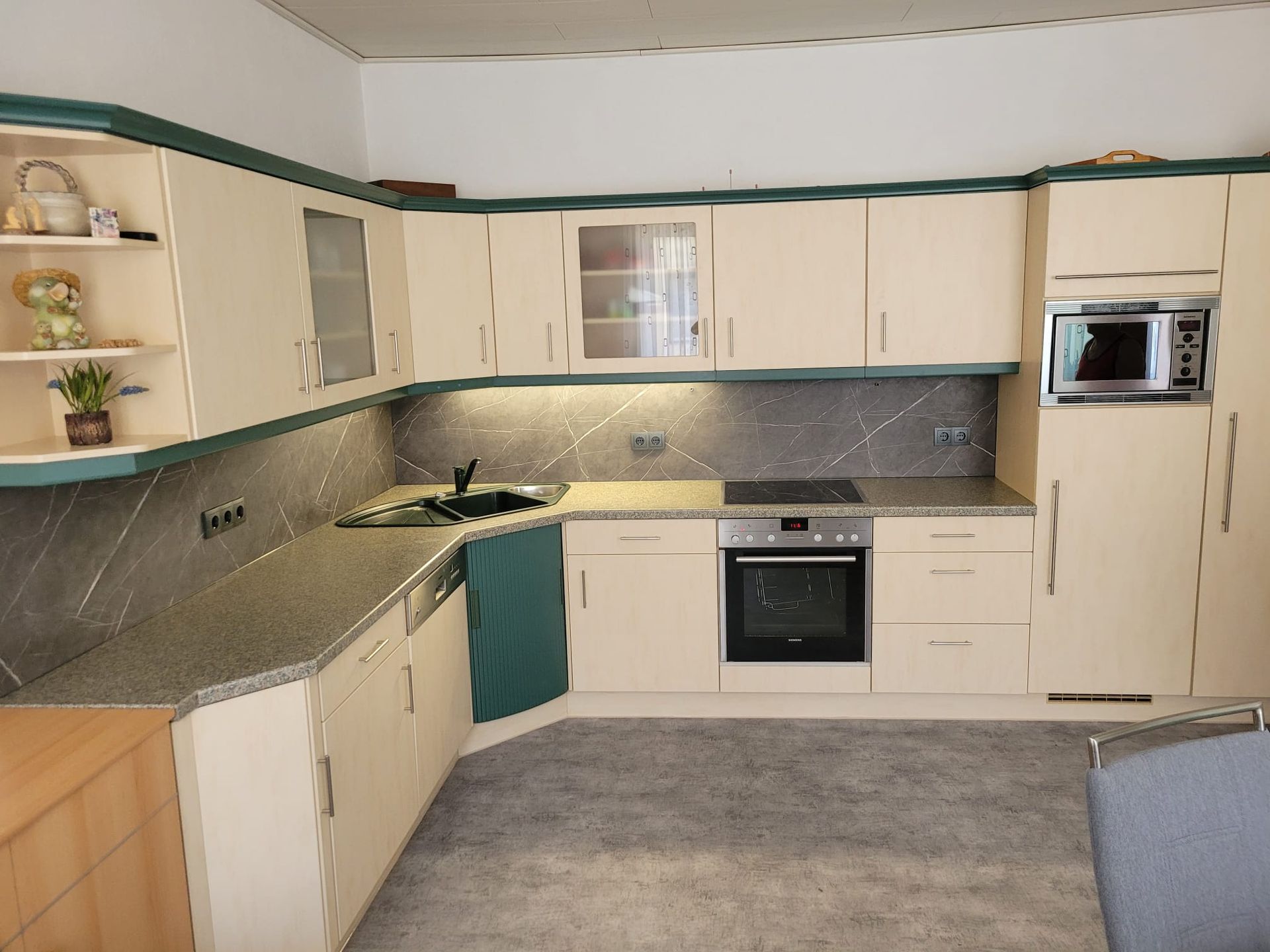 Eine Küche mit weißen Schränken und Granitarbeitsplatten