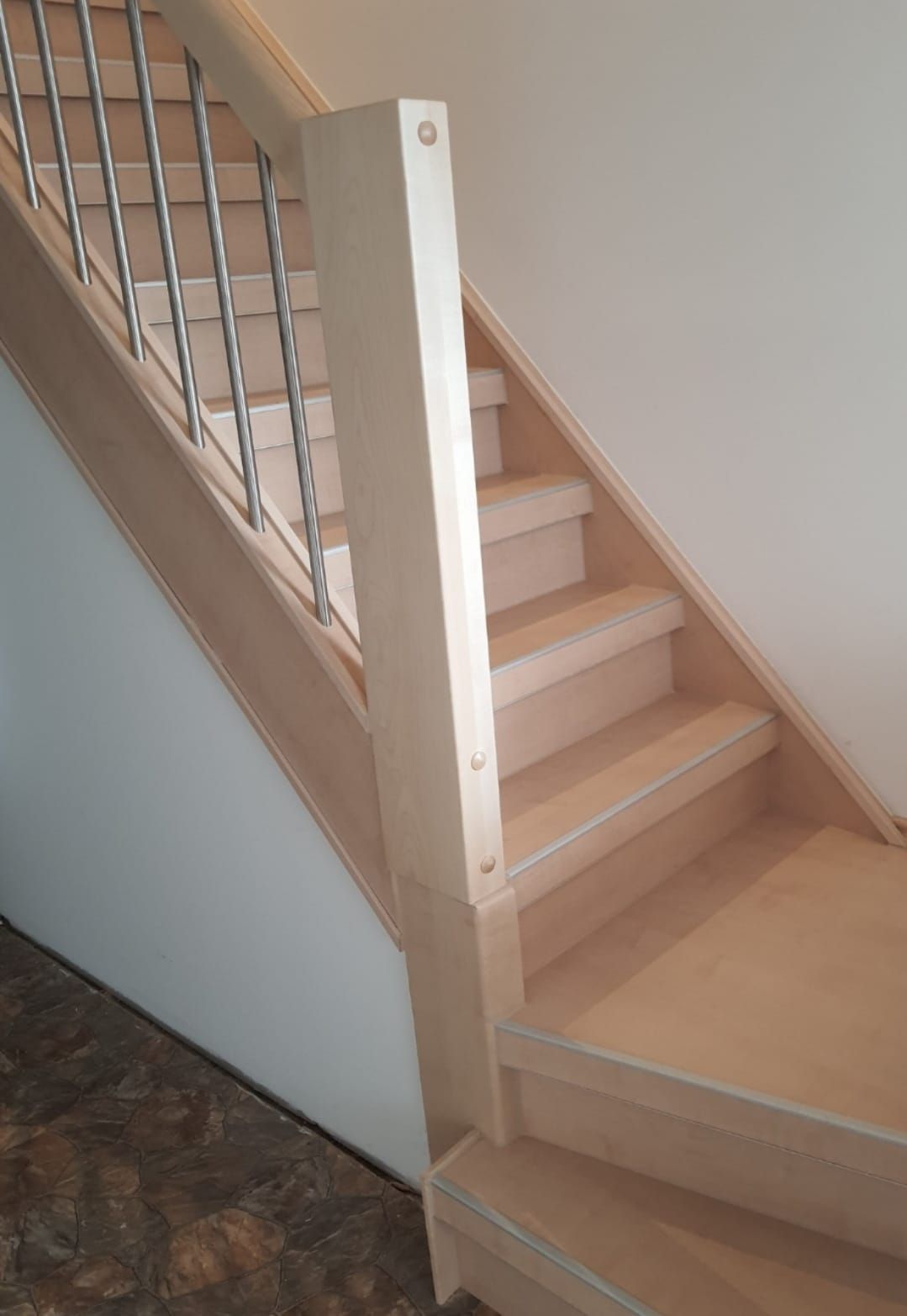 Eine Holztreppe mit einem Metallgeländer in einem Raum