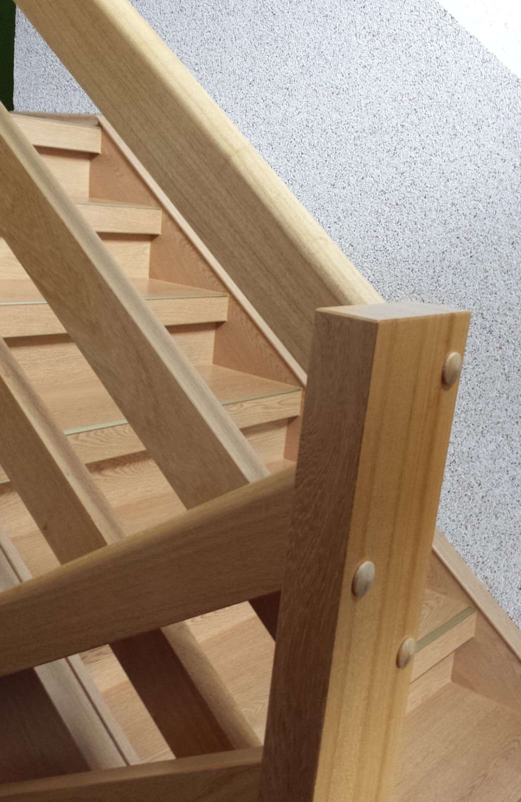 Eine Nahaufnahme einer Holztreppe mit Geländer