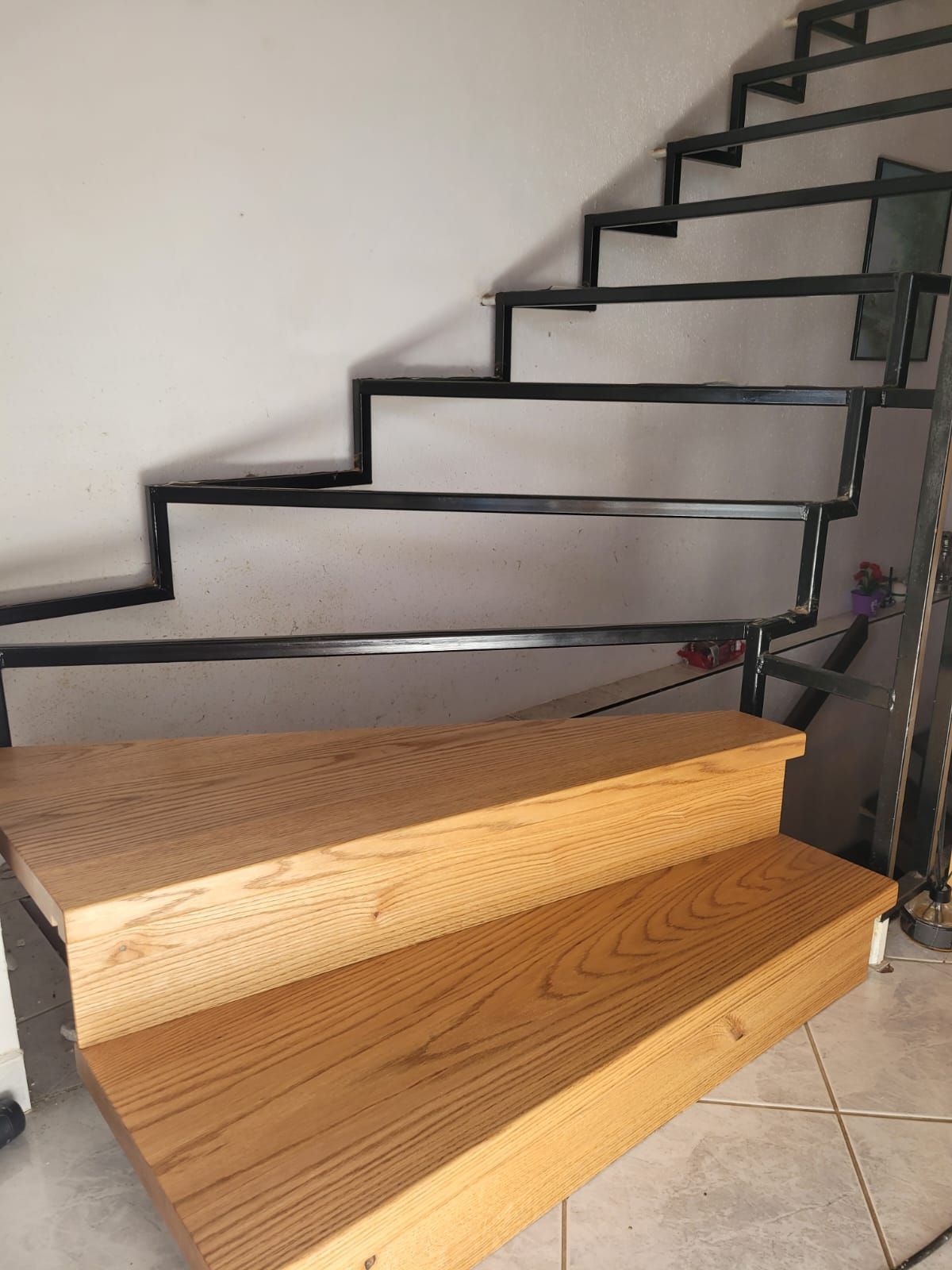 Eine Holztreppe mit einem Metallgeländer in einem Haus.
