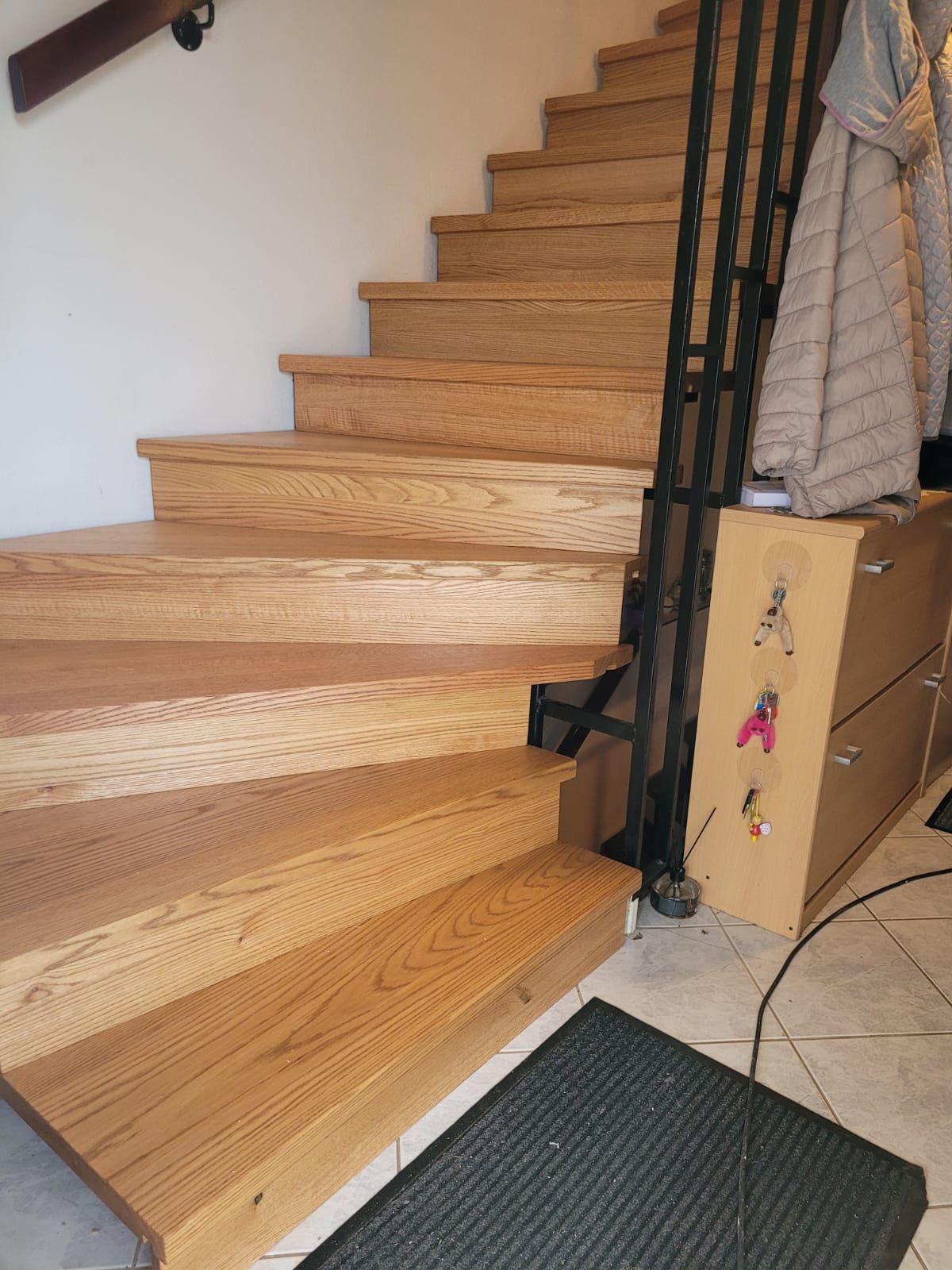 Eine Holztreppe mit einer schwarzen Matte auf dem Boden.