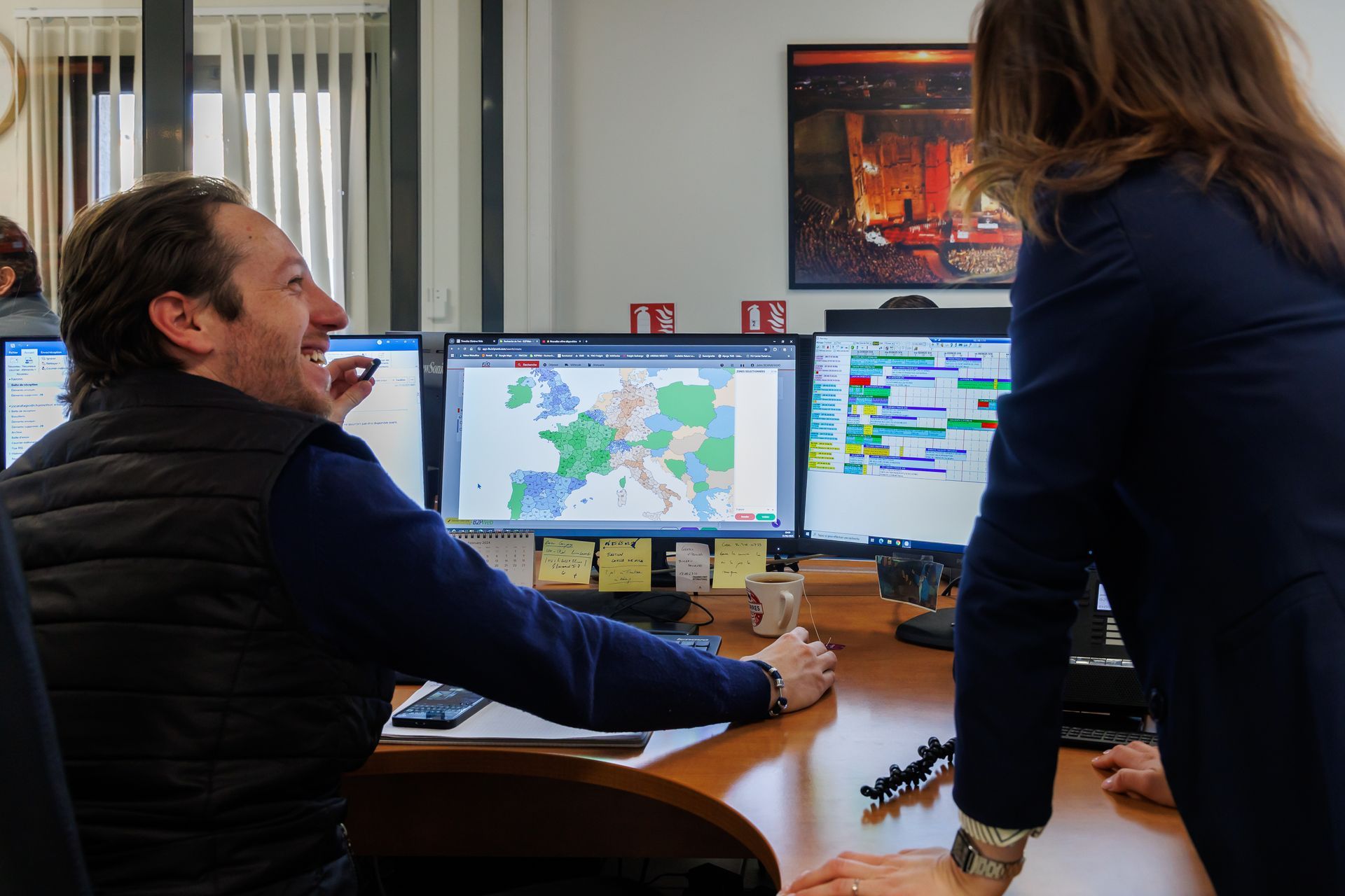 Deux personnes devant des écrans d'ordinateur