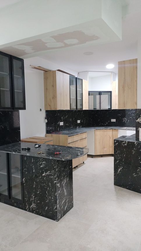 Una cocina con encimera de granito negro y gabinetes de madera.
