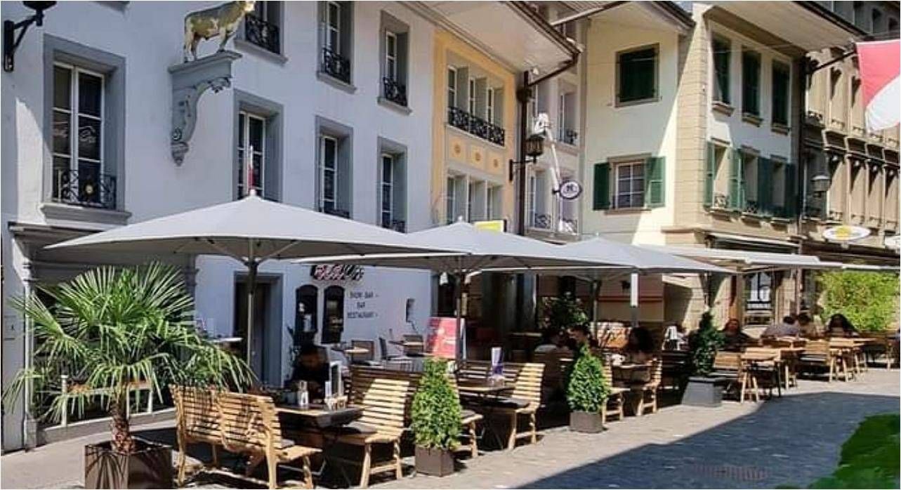 Terrasse eines Restaurants im Stadtzentrum mit Sonnenschirmen