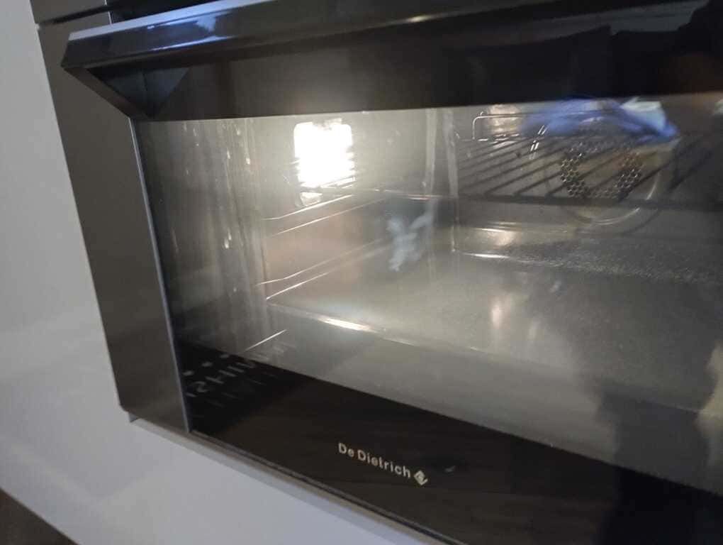 Horno tostador negro para encimera, con puerta de cristal y rejilla metálica en el interior