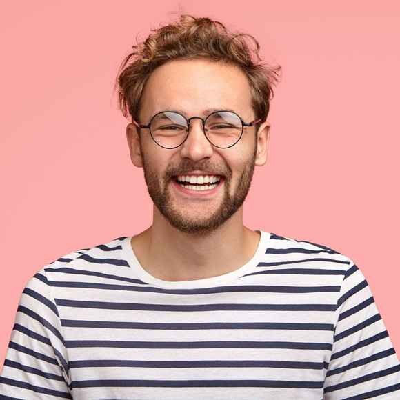 Un homme sourit avec des lunettes