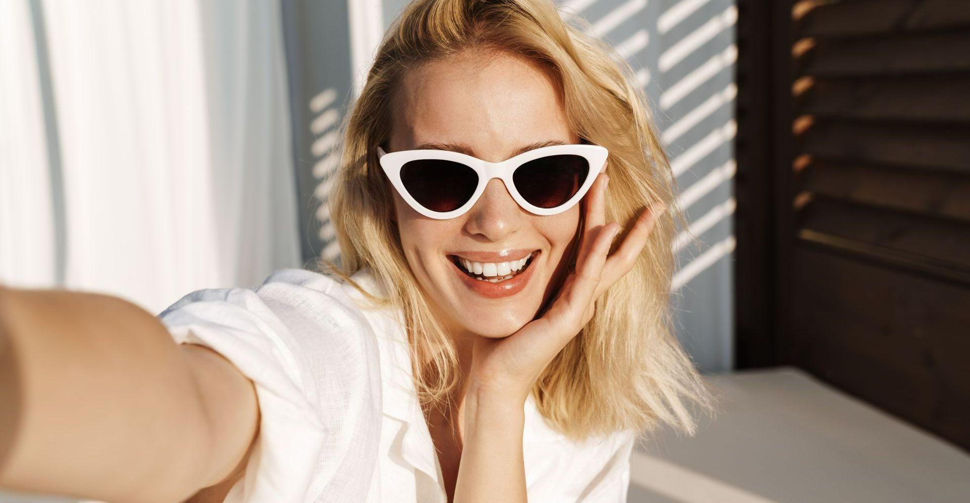 Une femme en chemise avec des lunettes blanches