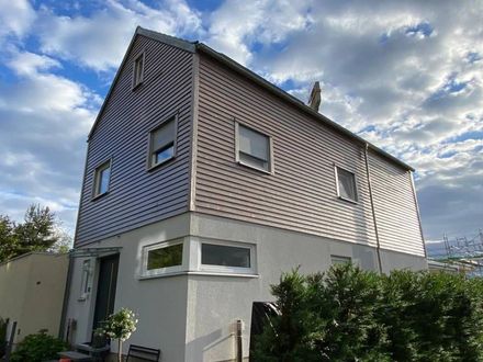 Ein Haus mit vielen Fenstern und einem blauen Himmel im Hintergrund. Foto von Saladin Maler