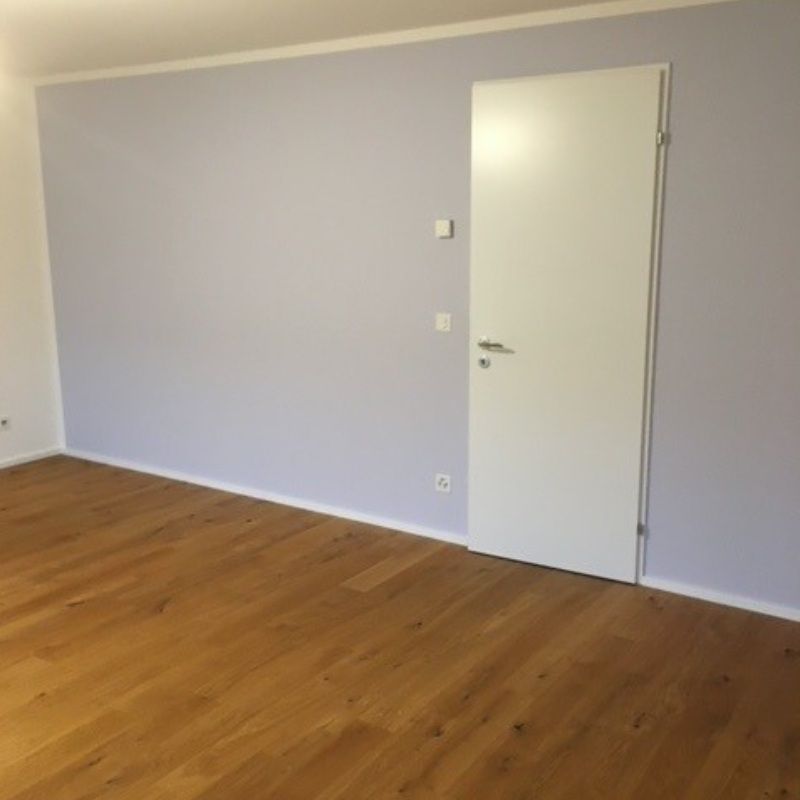 Ein leerer Raum mit violetten Wänden und einer weissen Tür. Foto von Saladin Maler