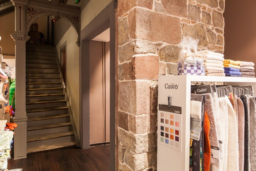 Ein Geschäft mit einer Treppe und einem Regal mit Kleidung darauf