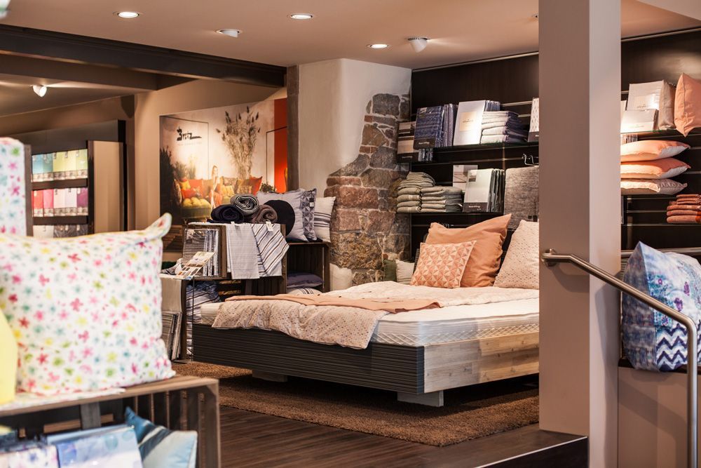 Ein Schlafzimmer mit einem Bett und Kissen in einem Laden.