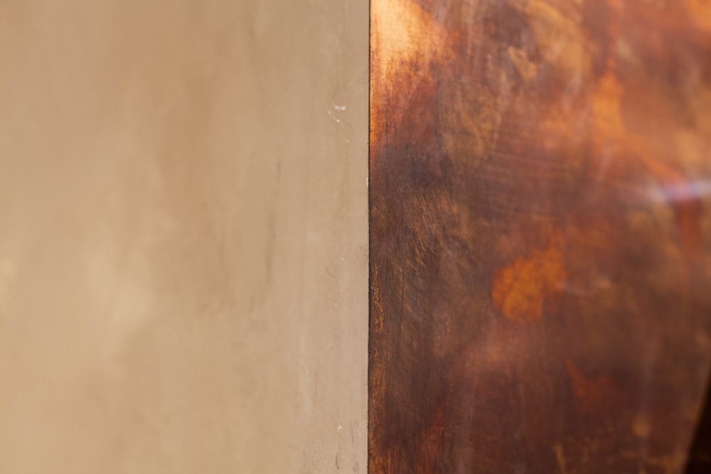 Eine Nahaufnahme eines Stücks Holz neben einer Wand.