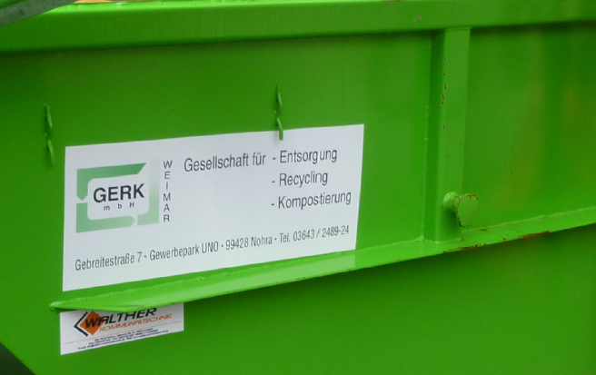 Gelber Baubagger kippt Erde ab, blauer Himmel im Hintergrund.