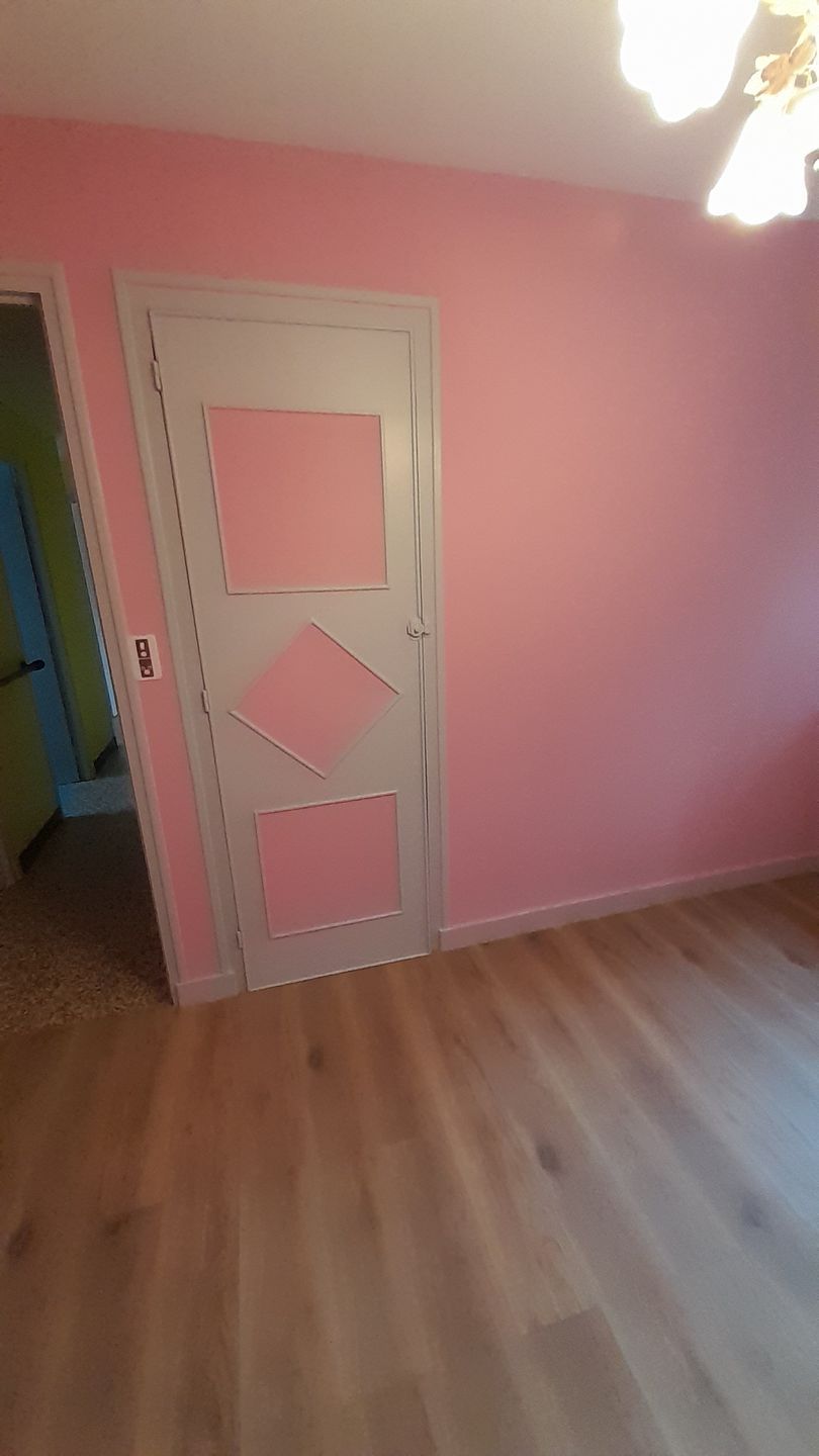 Pièce peinte en rose avec porte blanche