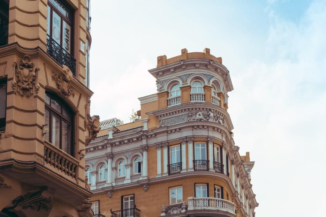 Fontanero utiliza una herramienta múltiple para ajustar tuberías y accesorios de cobre contra una pared blanca.
