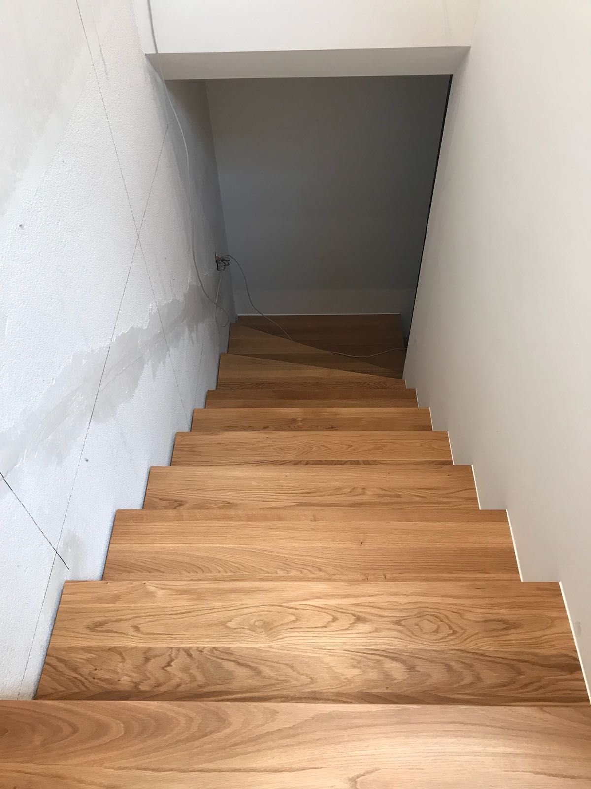 Eine Holztreppe mit einer weißen Wand dahinter