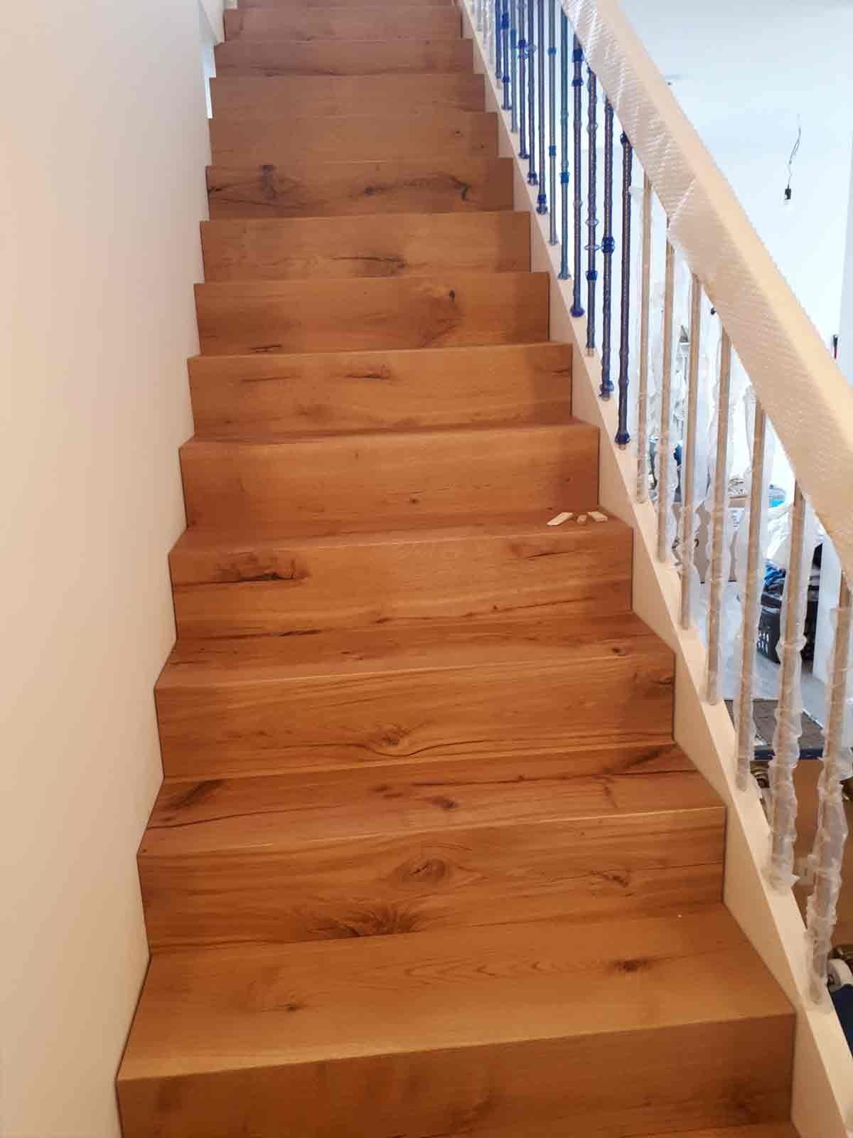 Eine Holztreppe mit einem weißen Geländer in einem Haus.