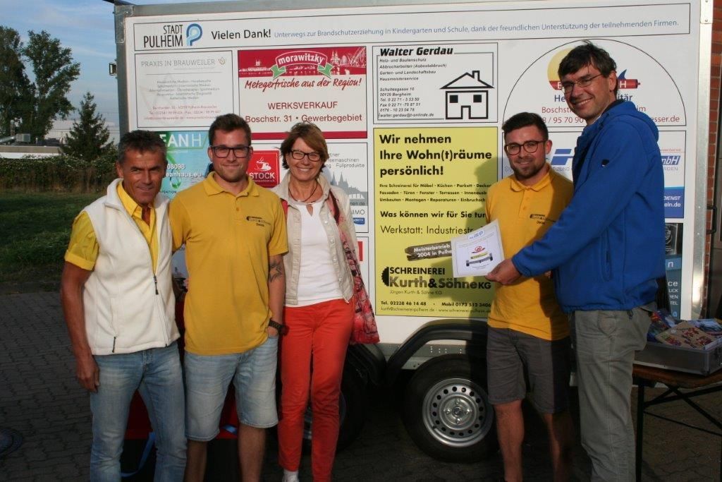 Eine Gruppe von Menschen steht vor einem Schild mit der Aufschrift 