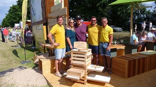 Eine Gruppe von Menschen posiert vor einem Holzdisplay für ein Foto.