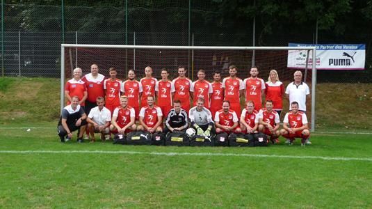 Eine Fußballmannschaft posiert für ein Mannschaftsfoto auf einem Feld