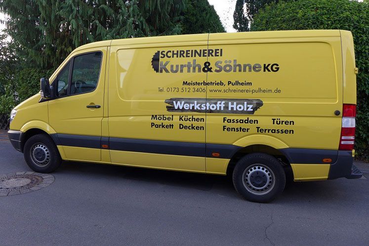 Auf einem gelben Lieferwagen steht Schreinerei Kurth & Söhne KG