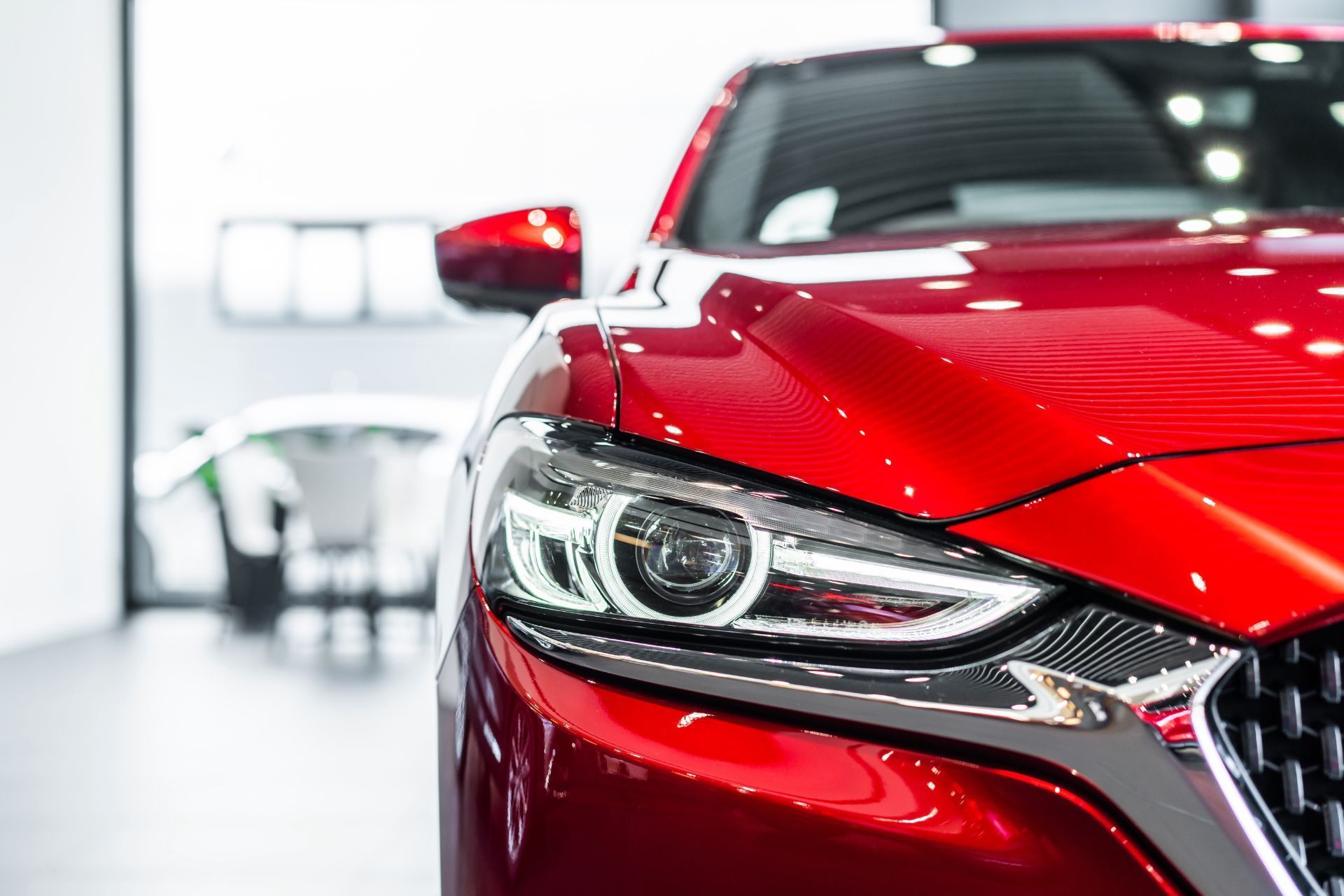 Edificio Omni Car Wash de color blanco con un logotipo verde y azul, bajo un cielo nublado.