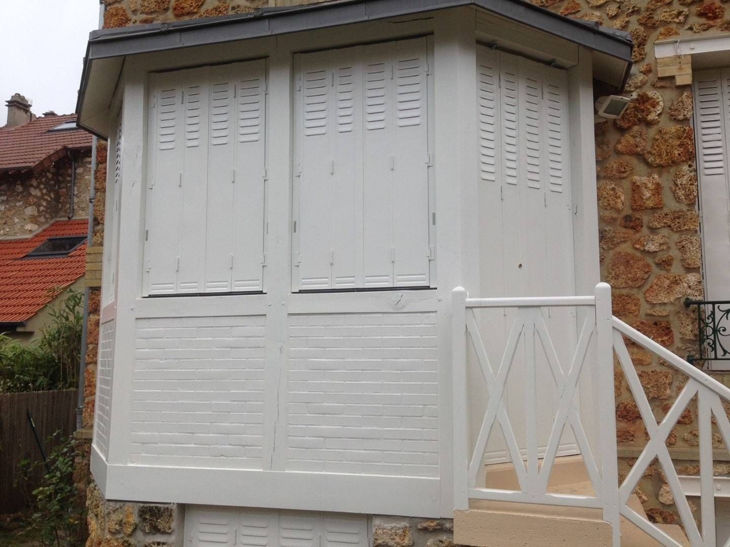 Volets battants blancs mi-persienne fermés après rénovation