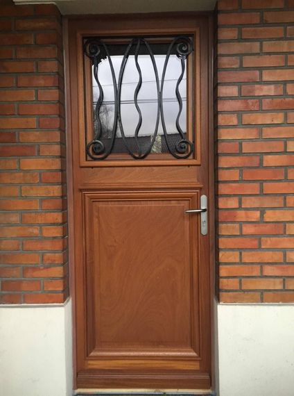 Porte d'entrée en bois avec maison en briques