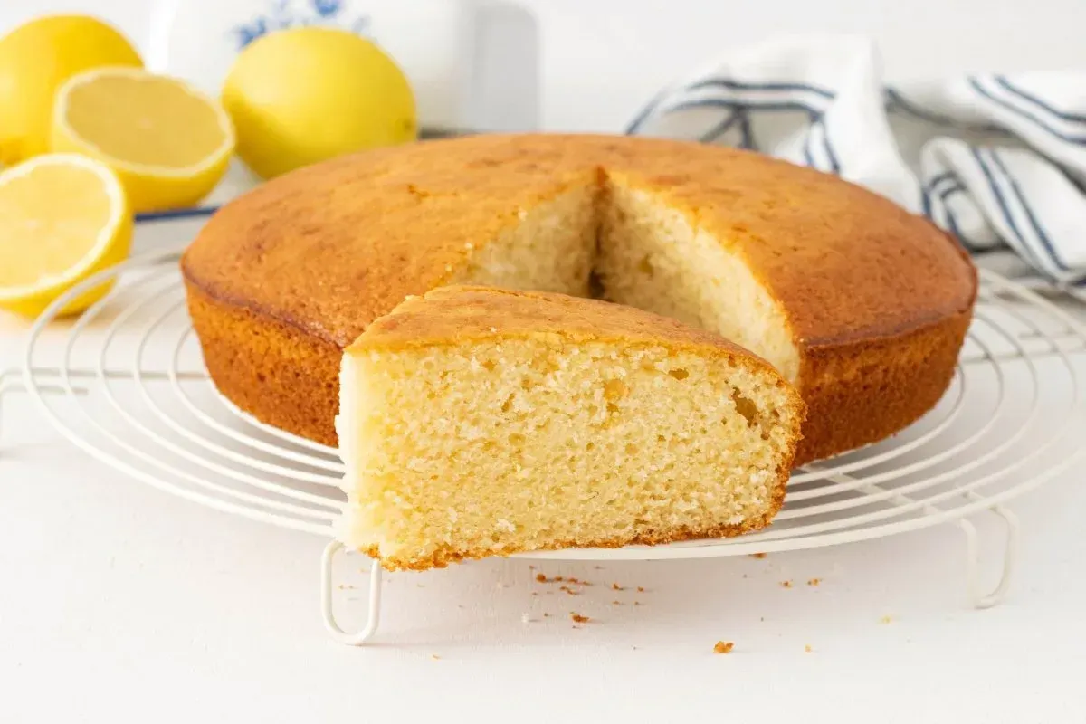 Pila de alfajores rellenos de chocolate, espolvoreados con coco, sobre una superficie moteada.