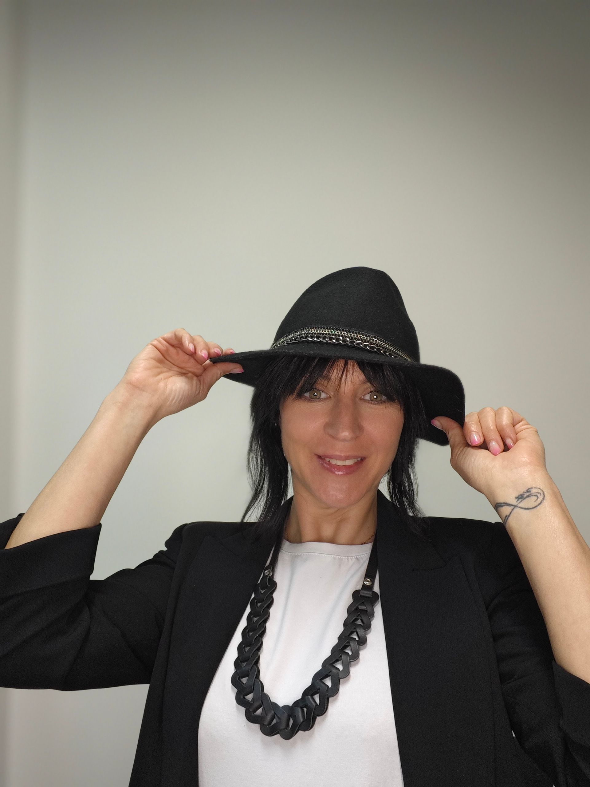 Una mujer con cabello largo y rubio está parada frente a un estante de productos para el cabello.