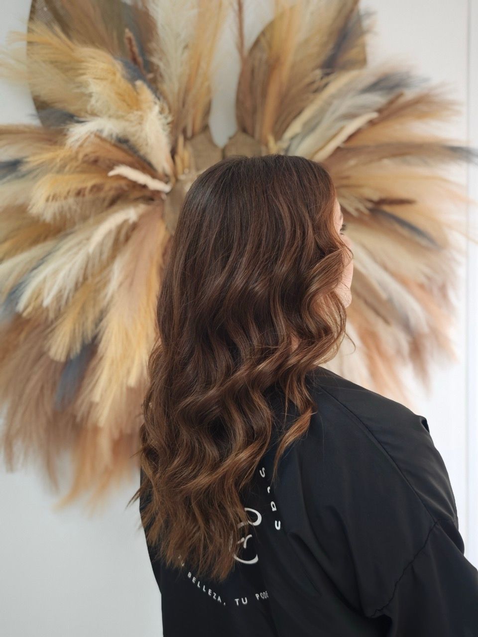 Una mujer con cabello rubio lleva una camiseta negra sin mangas.