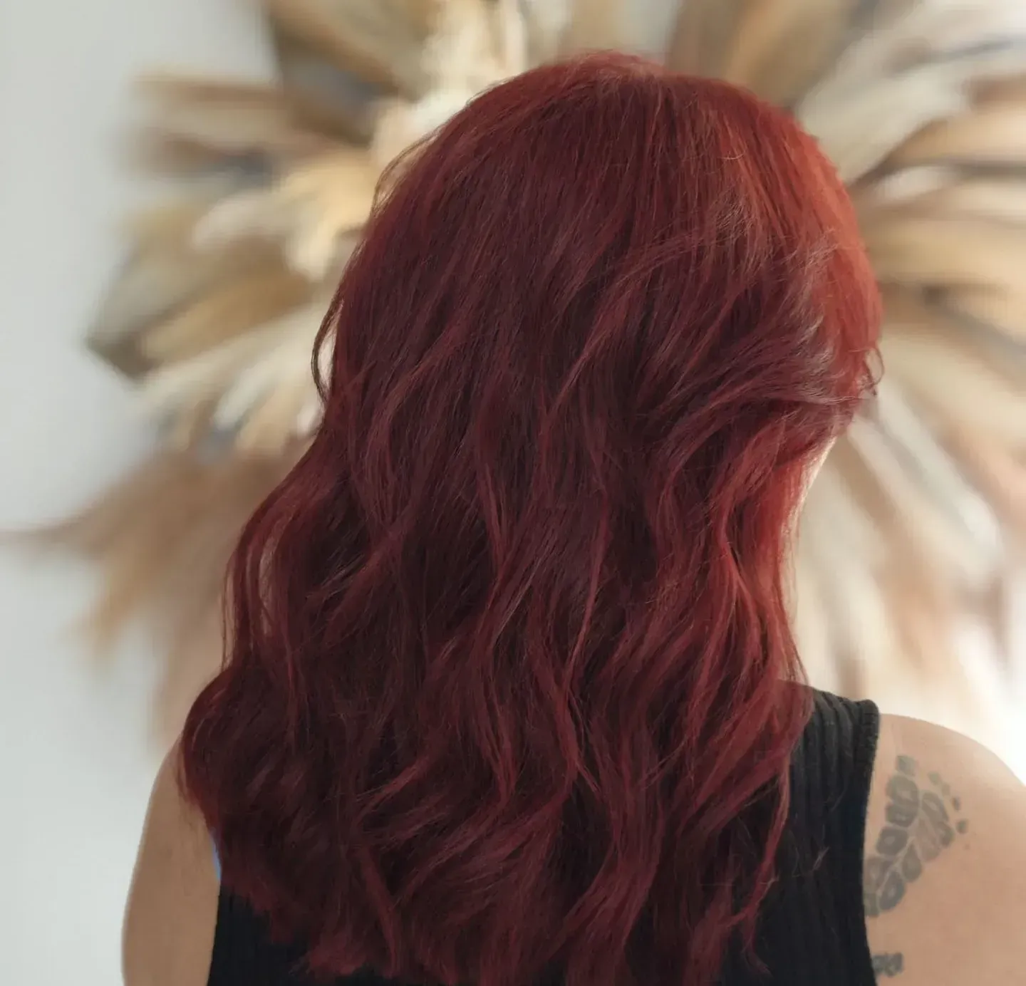 Una mujer con cabello rojo y un tatuaje en el brazo.