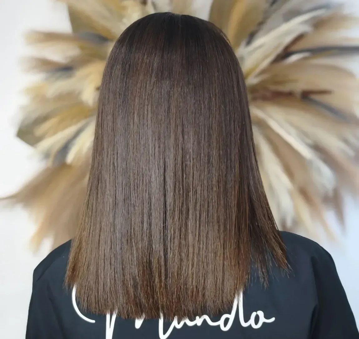 Una mujer con cabello largo lleva una camisa negra que dice vainilla.