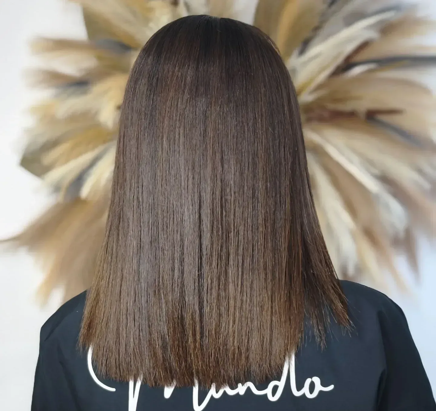 Una mujer con cabello largo lleva una camisa negra que dice vainilla.