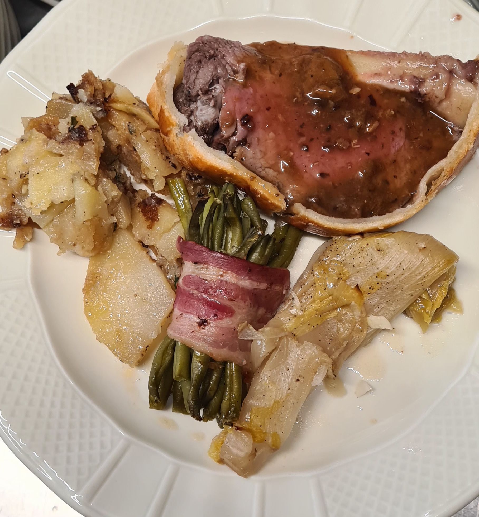 Assiette avec la viande en croûte et les légumes grillés.