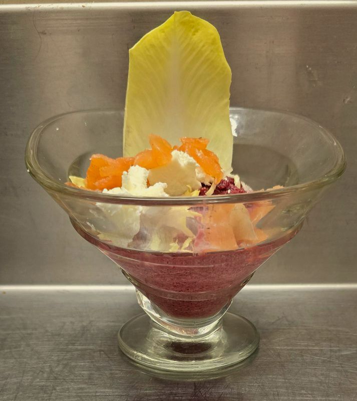 Verrine avec une entrée froide, décorée avec une feuille d'endive.
