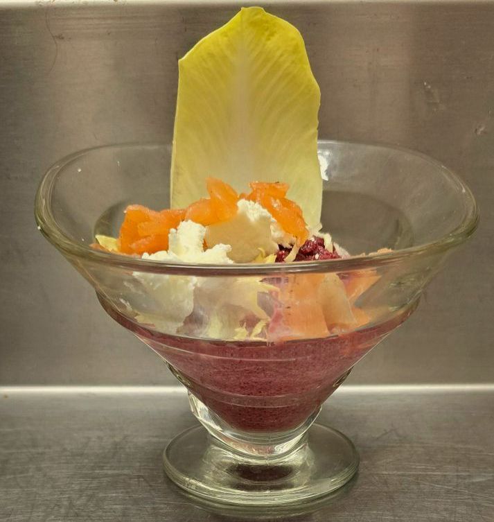Une verrine avec une entrée froide et une feuille d'endive.