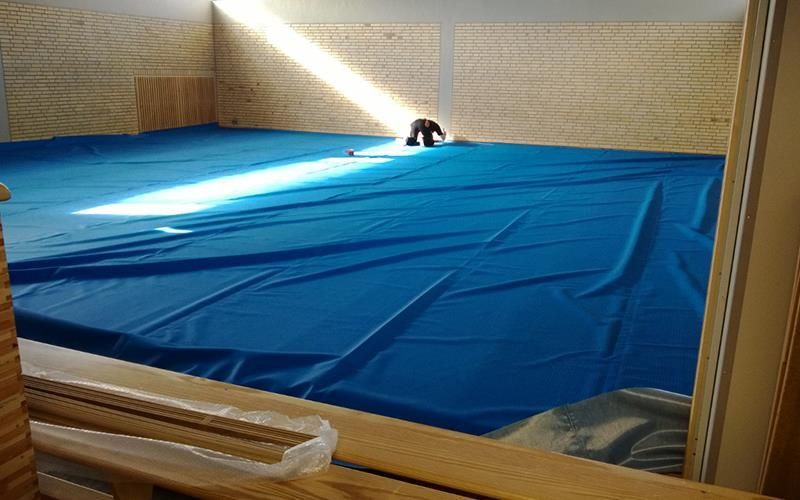 Eine Person liegt in einem Fitnessstudio auf einer blauen Matte.
