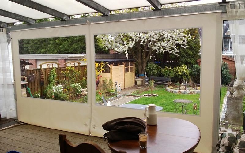 Eine Terrasse mit Tisch und Stühlen und Blick auf einen Garten.