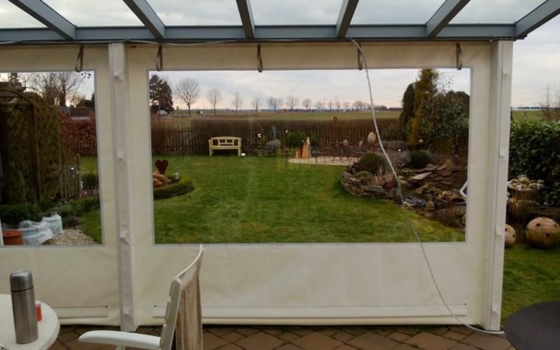 Ein Blick auf einen Garten durch ein Fenster in einem Pavillon.