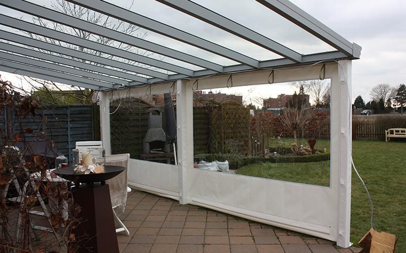 Eine Terrasse mit Tisch und Stühlen unter einem Baldachin.