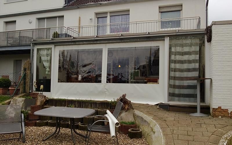 Eine Terrasse mit Tisch und Stühlen vor einem Haus.