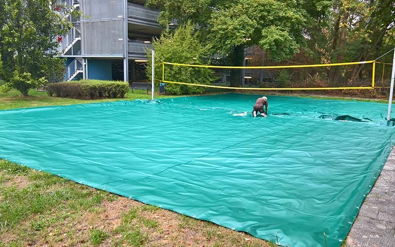 Ein Mann spielt Volleyball auf einem mit einer Plane bedeckten Volleyballfeld.