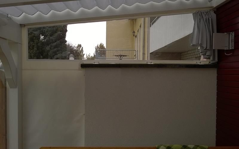 In der Wand befindet sich ein Fenster, das auf einen Balkon hinausgeht.