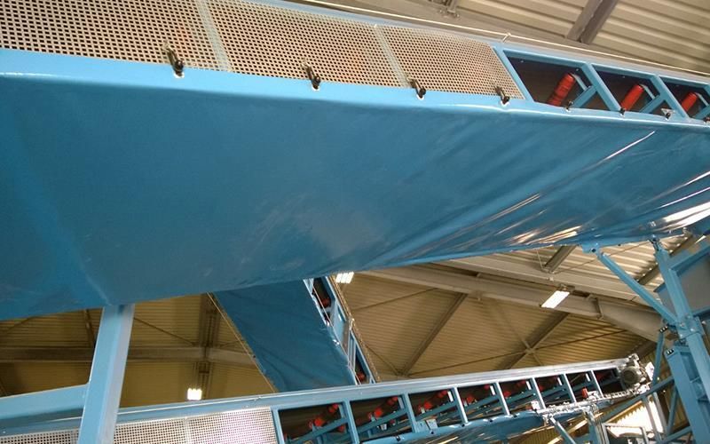 In einer Fabrik wird ein blaues Förderband verwendet.