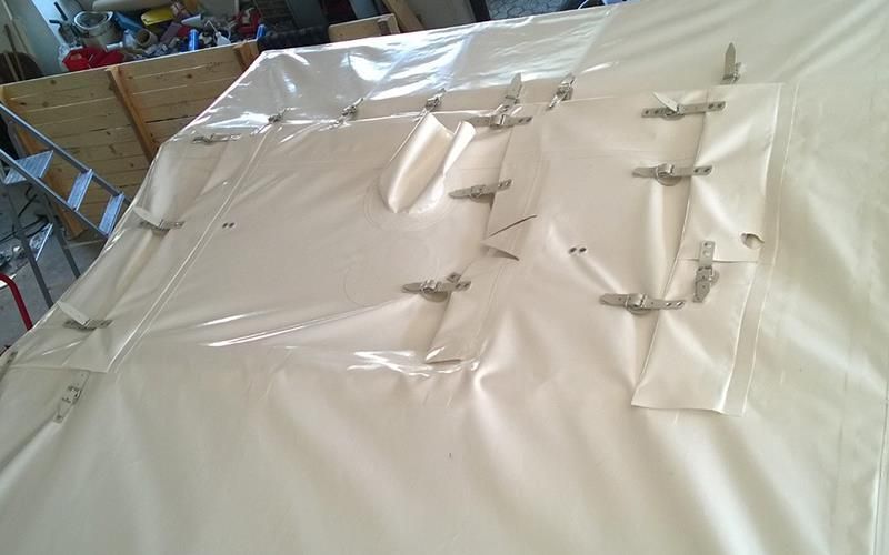 Auf einem Holztisch liegt ein großes Stück Plastik.