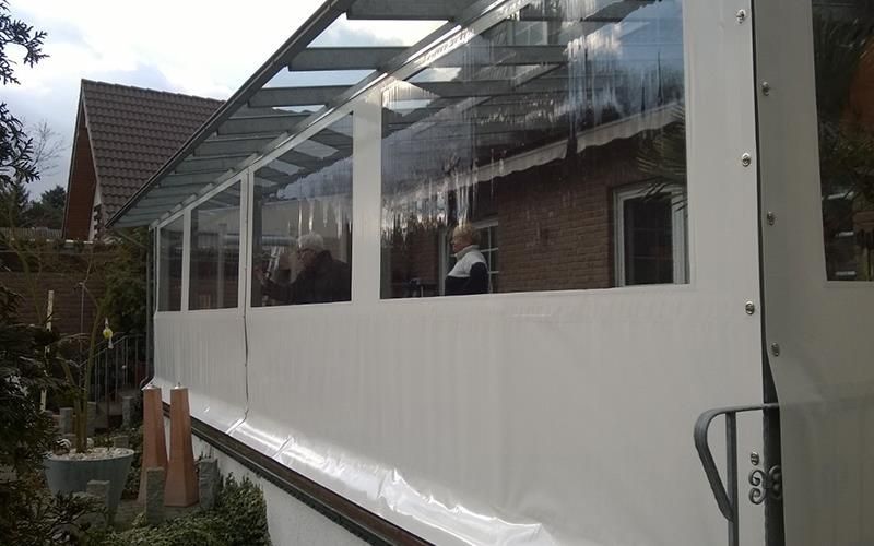 Ein weißes Gebäude mit vielen Fenstern und einem Dach