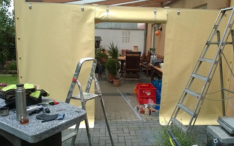 Eine Leiter lehnt an einer Wand in einem Hinterhof