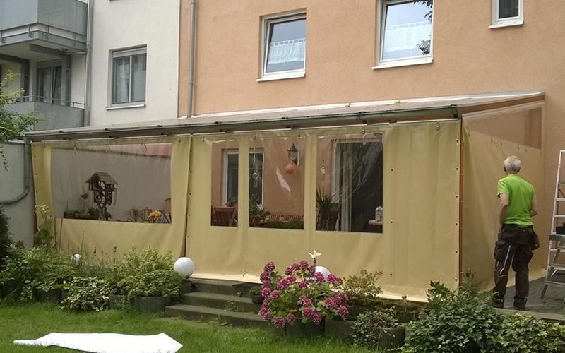 Ein Mann in einem grünen Hemd steht vor einem Gebäude